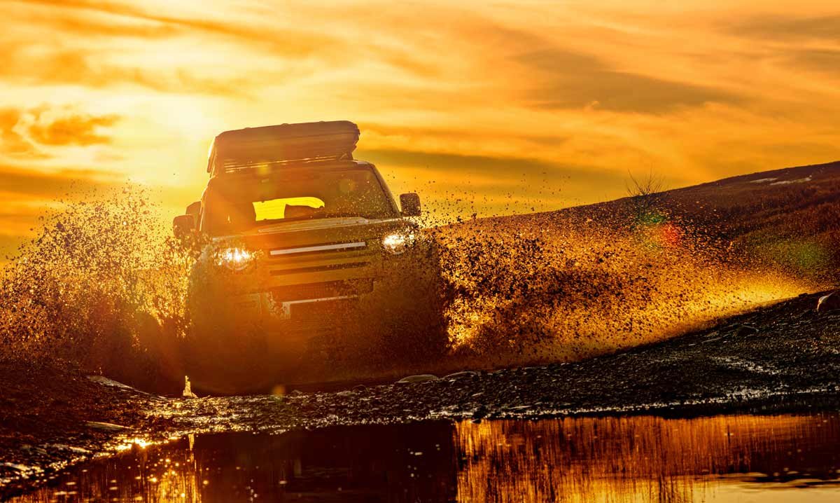 SUV driving through harsh environment at sunset